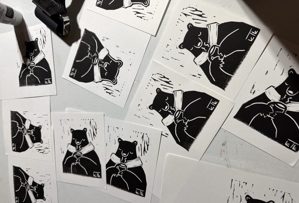 linocut art of a bear holding a mug